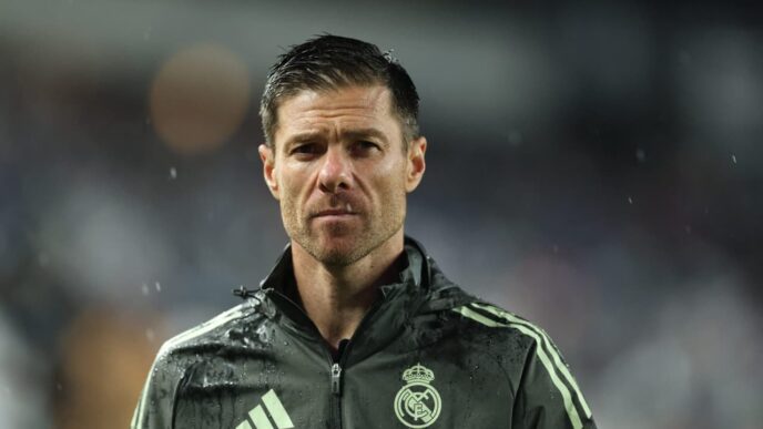 Xabi Alonso em jogo pelo Real Madrid, com torcedores pedindo Rodrygo como titular na Champions League.