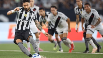 Alex Telles marcando de pênalti em uma partida do Botafogo contra o Vasco.
