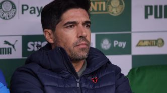Abel Ferreira, técnico do Palmeiras, em campo, sorrindo.