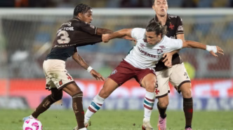 Jogadores de Vasco e Fluminense disputam a bola intensamente em campo no Estádio do Maracanã.