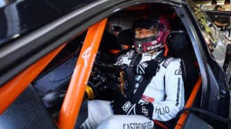 Helio Castroneves em seu carro de corrida no autódromo de Velocitta, focado na pista.