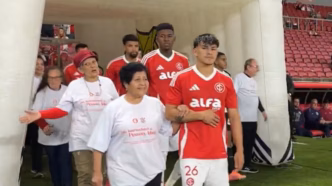 Jogadores do Internacional e Corinthians entram em campo com idosos em homenagem.
