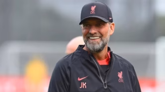 Jürgen Klopp em ação como técnico do Liverpool, sorrindo durante uma partida.