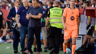 Técnico do Barcelona, Hansi Flick, em observação atenta durante a partida.