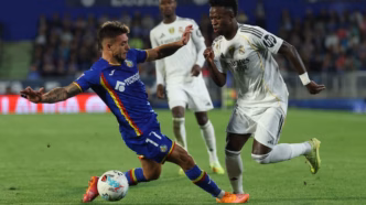 Vini Jr driblando adversário durante partida entre Real Madrid e Getafe.