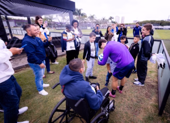 Jogadores do Corinthians interagindo com crianças da ONG Make-A-Wish Brasil