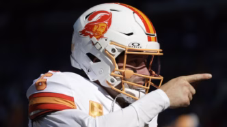 Baker Mayfield lançando a bola pelo Tampa Bay Buccaneers em um jogo da NFL.