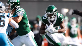 Breece Hall correndo com a bola em jogo da NFL.