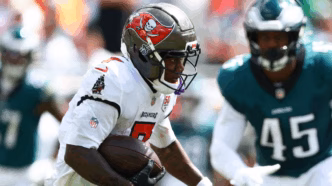Bucky Irving em ação com a bola em campo pelo Tampa Bay Buccaneers.
