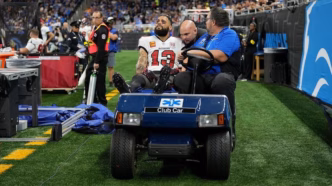 Mike Evans sendo retirado de campo em maca durante jogo dos Buccaneers contra os Lions.
