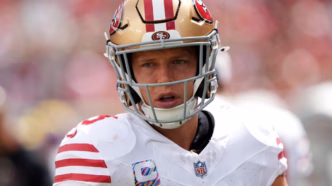 Christian McCaffrey, running back do San Francisco 49ers, correndo com a bola durante uma partida.