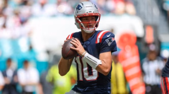 Drake Maye em ação com o uniforme dos New England Patriots em jogo da NFL.