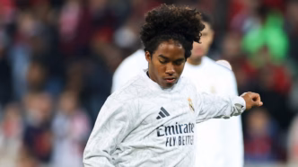 Endrick em aquecimento, com semblante frustrado, no banco de reservas do Real Madrid.