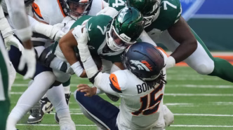 Justin Fields em campo durante jogo da NFL, com o número 1 em seu uniforme.