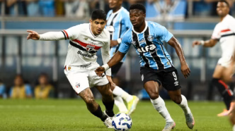 Jogo entre Grêmio e São Paulo, com foco no campo e torcida.
