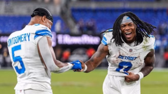 David Montgomery e Jahmyr Gibbs dos Detroit Lions comemorando uma jogada em campo.