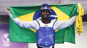 Henrique Marques em ação na luta de taekwondo com foco na pontuação.