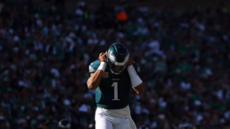 Quarterback Jalen Hurts analisa jogada durante partida dos Eagles.