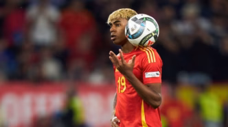Lamine Yamal em campo pela seleção espanhola, vestindo o uniforme vermelho.