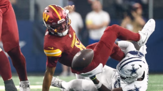 Jayden Daniels, quarterback dos Washington Commanders, em ação durante partida da NFL.