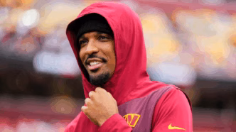 Jayden Daniels, quarterback dos Commanders, recebendo atendimento médico em campo após lesão.