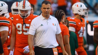 Treinador Mario Cristobal em jogo de futebol americano universitário, destacando a importância do College Football.