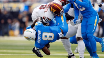 Omarion Hampton dos Chargers em ação com a bola.