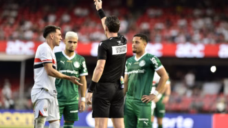 Jogadores de São Paulo e Palmeiras em campo durante o Choque-Rei, com foco em lance de cartão amarelo.