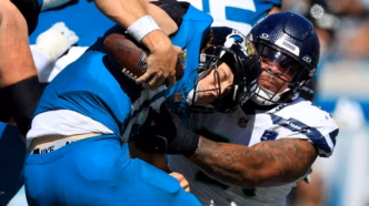Jogadores do Seattle Seahawks aplicando pressão no quarterback adversário em partida da NFL Semana 6.