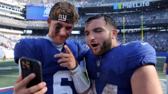 Jaxson Dart e Cam Skattebo correndo com a bola em campo em jogo dos Giants.