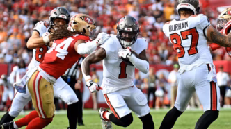 Fred Warner dos 49ers sendo atendido após lesão no pé contra os Buccaneers