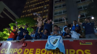 Roger Silva comemora o acesso do Londrina à Série B, tirando a camisa durante desfile em carro de bombeiros.