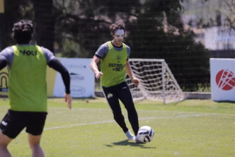 Nicolas, atacante do Criciúma, treinando com máscara de proteção facial para o retorno em campo.